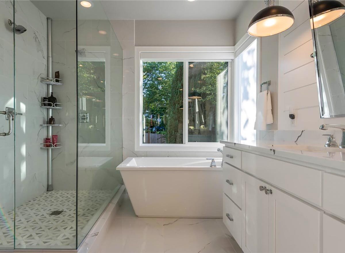 Primary bathroom with a walk-in shower and a soaking tub under the sliding windows.