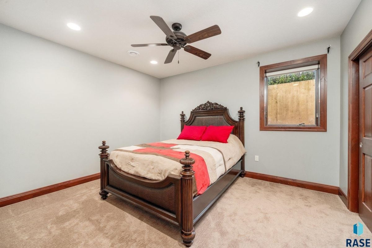 Bedroom with a large bed, carpet flooring, and glass window.