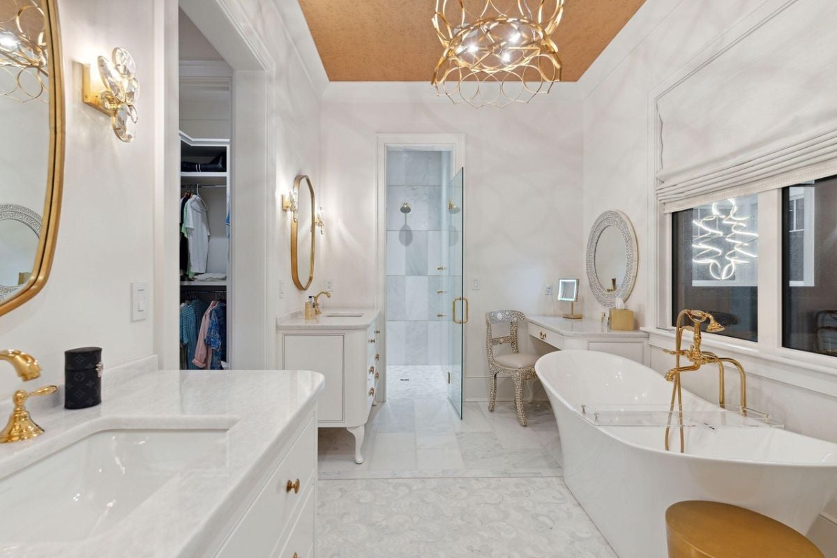 Bathroom with dual sinks, custom lights, soaking tub and a walk-in shower.