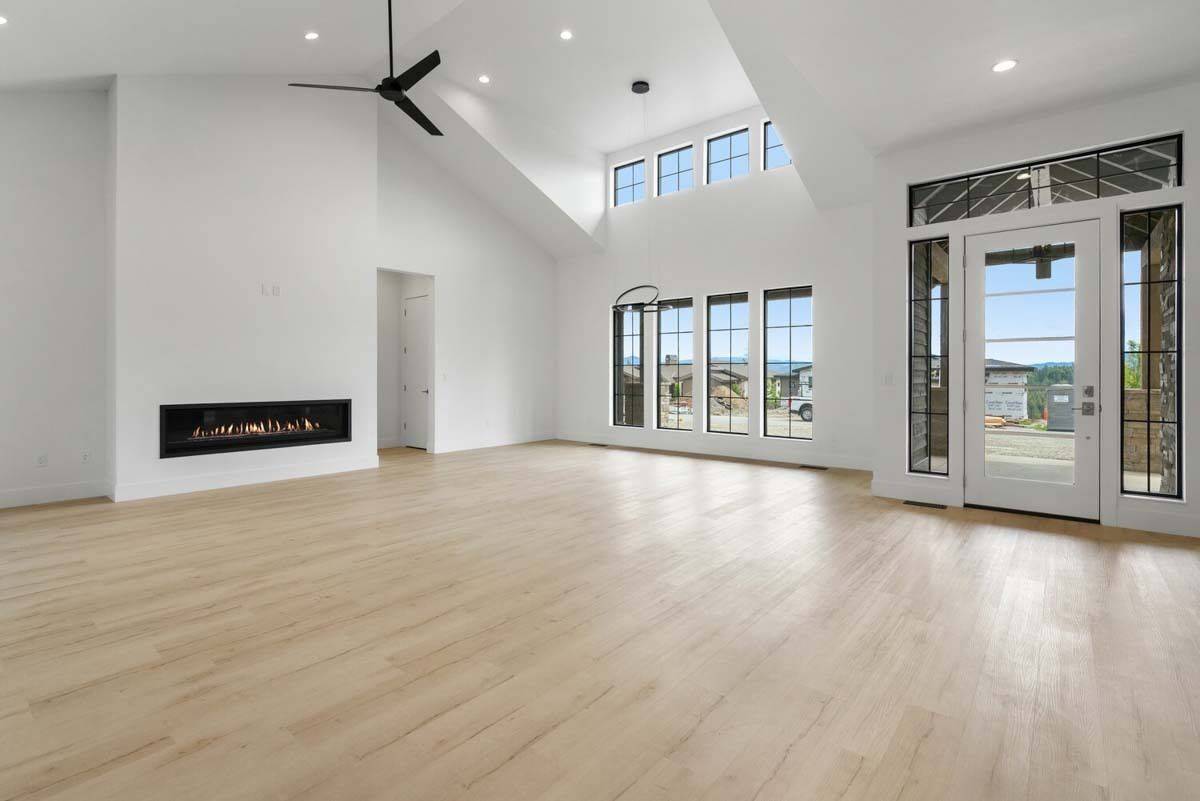 Huge windows and a glazed door fill the living room with abundant natural light.