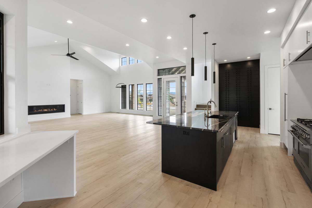 Kitchen and living room with hardwood flooring and white walls.
