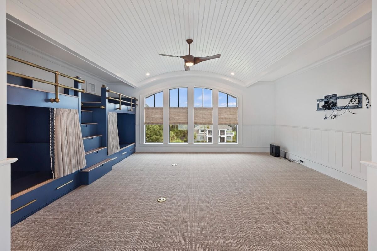 Bedroom with carpet flooring, bunks and glass windows.