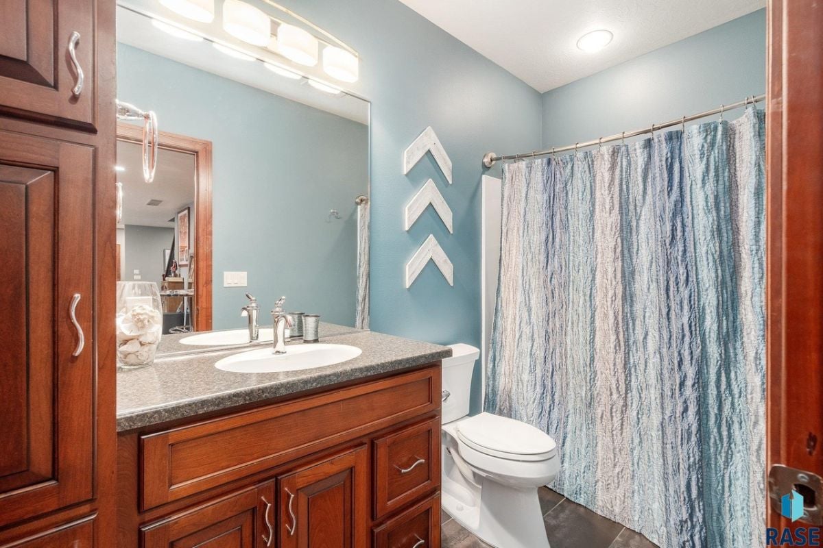 Bathroom with a sink, a large mirror and a toilet.