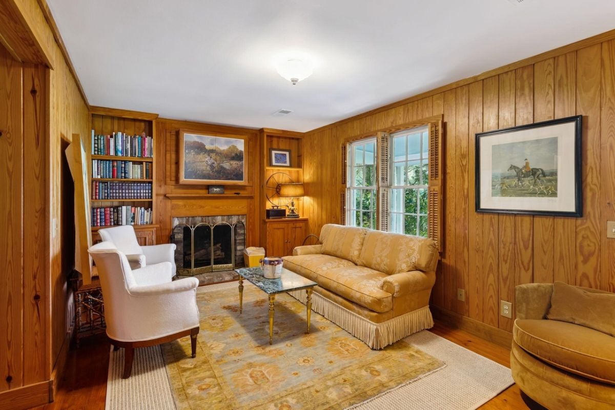 Living room with couches, a large rug and a fireplace.