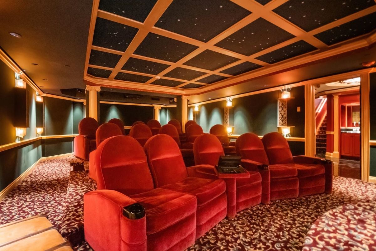 Home theater with red chairs and custom lights.