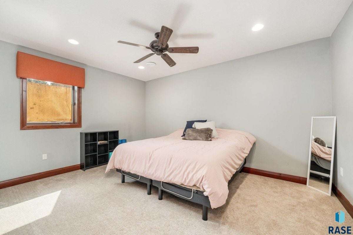 Bedroom with a large bed, carpet flooring, and glass window.