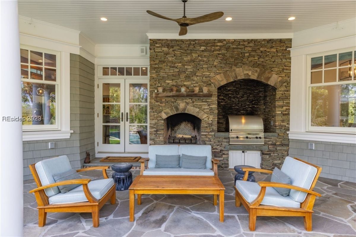 Patio with a table, chairs, and a fireplace.