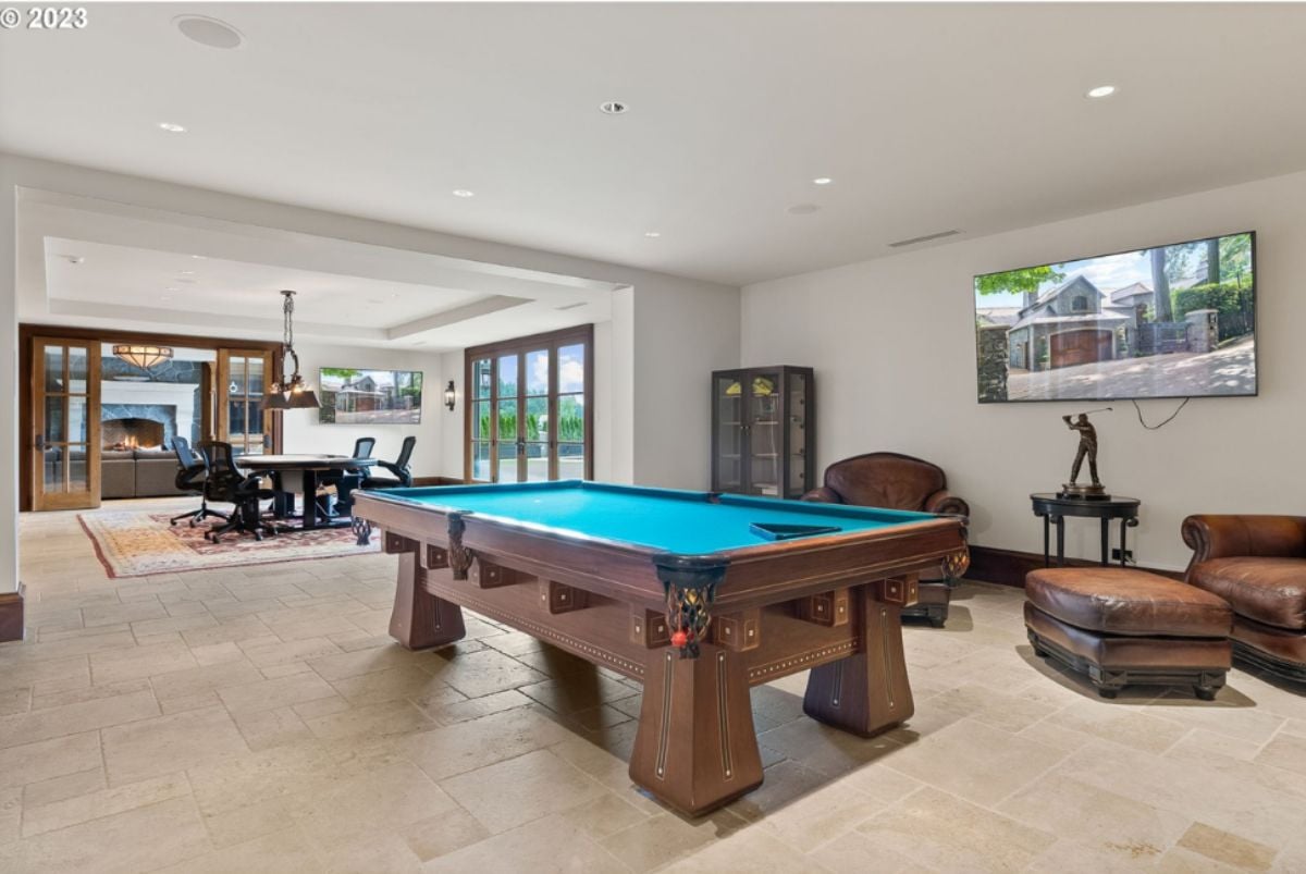 Recreation room with billiards table, TV and couches.