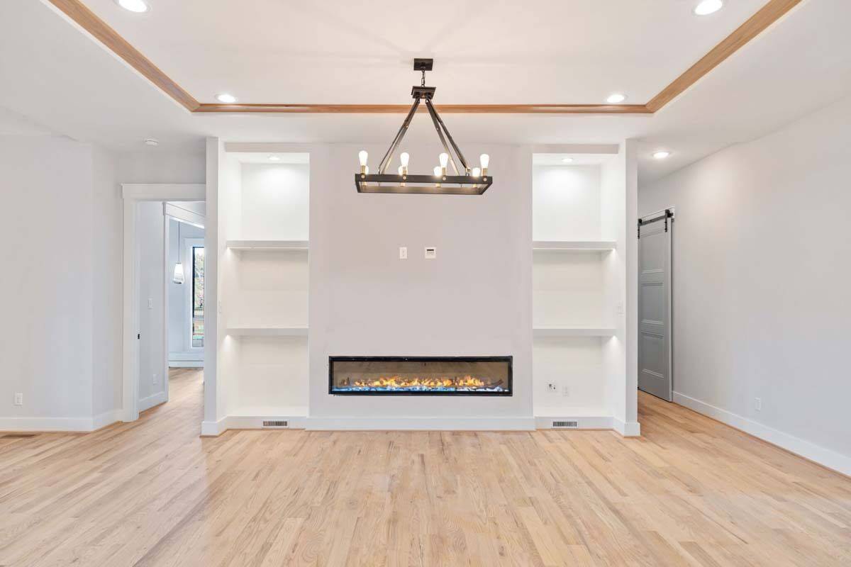 Family room with a linear fireplace flanked by built-in shelves.