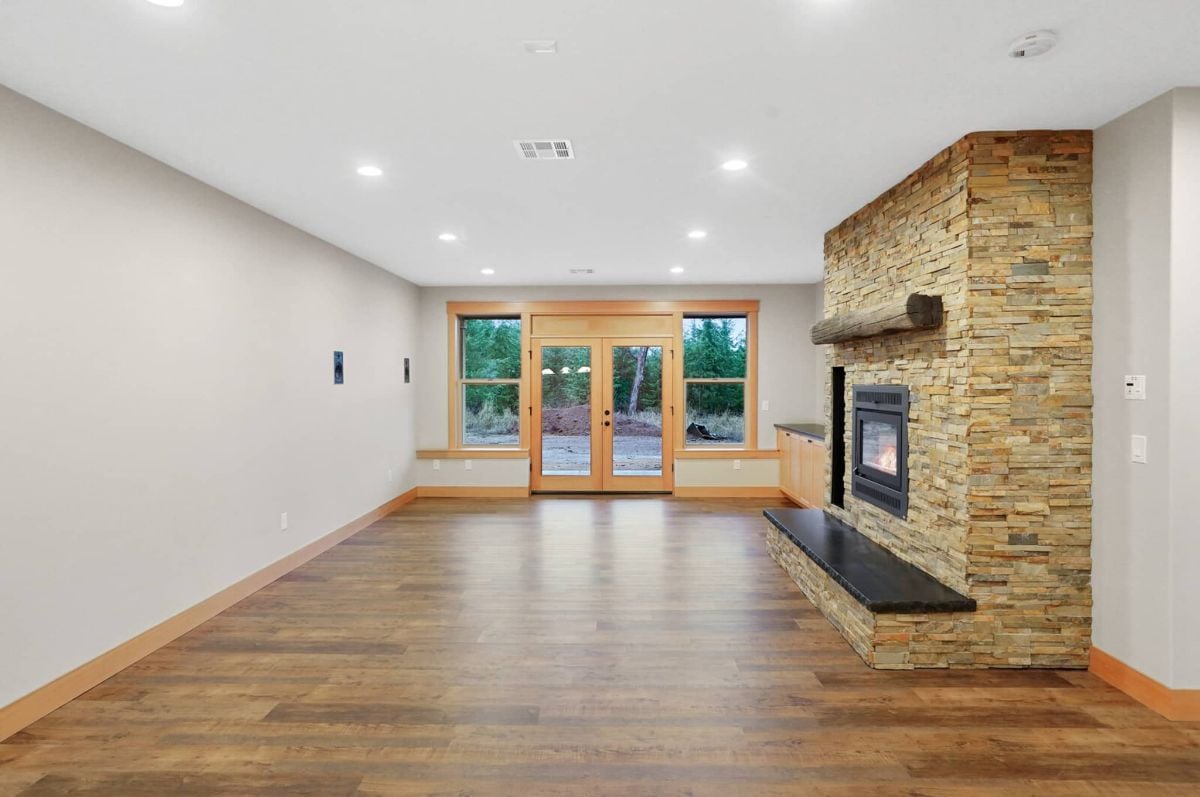 Living room with custom lights, a fireplace, and glass doors.