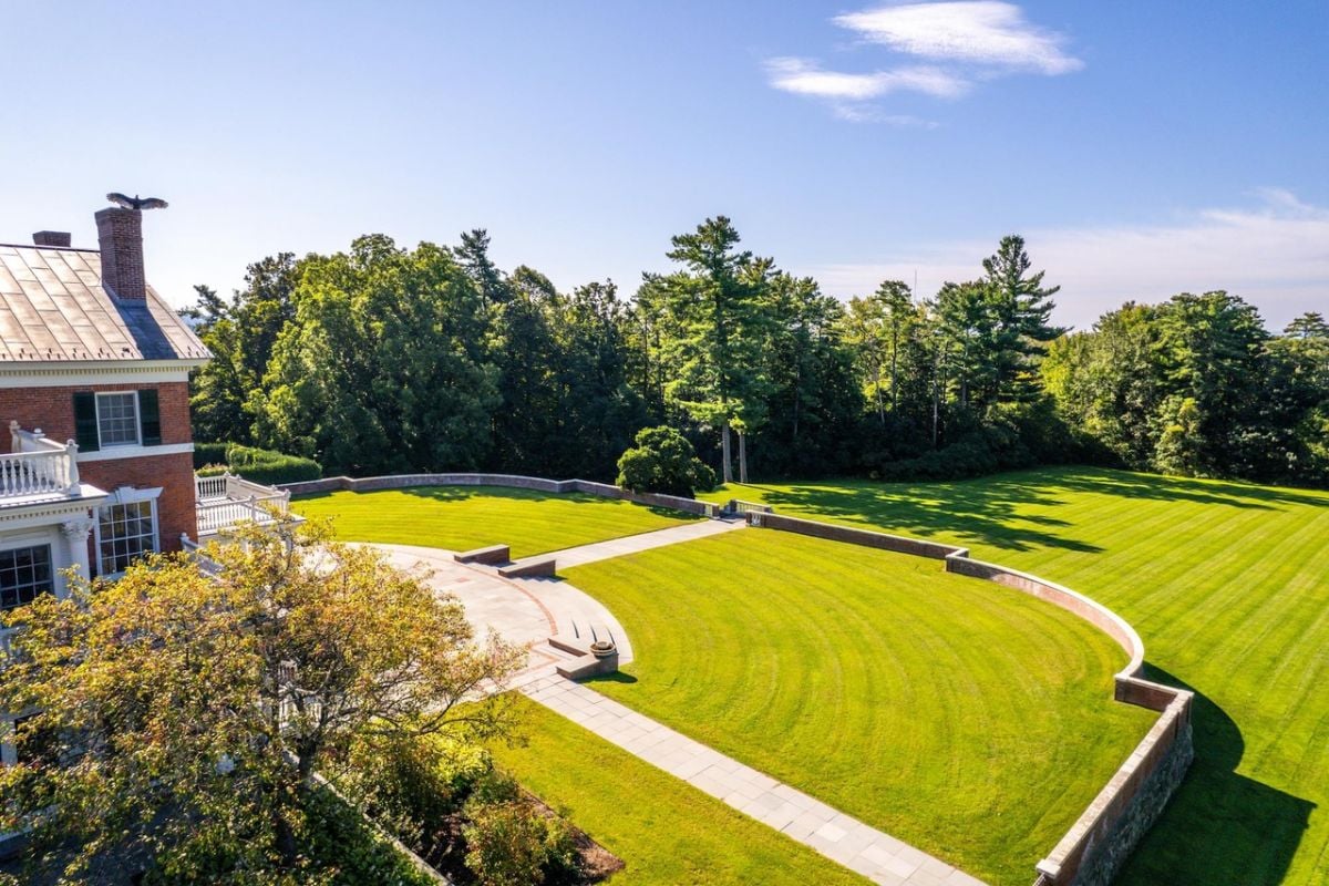 Backyard with a large green lawn.