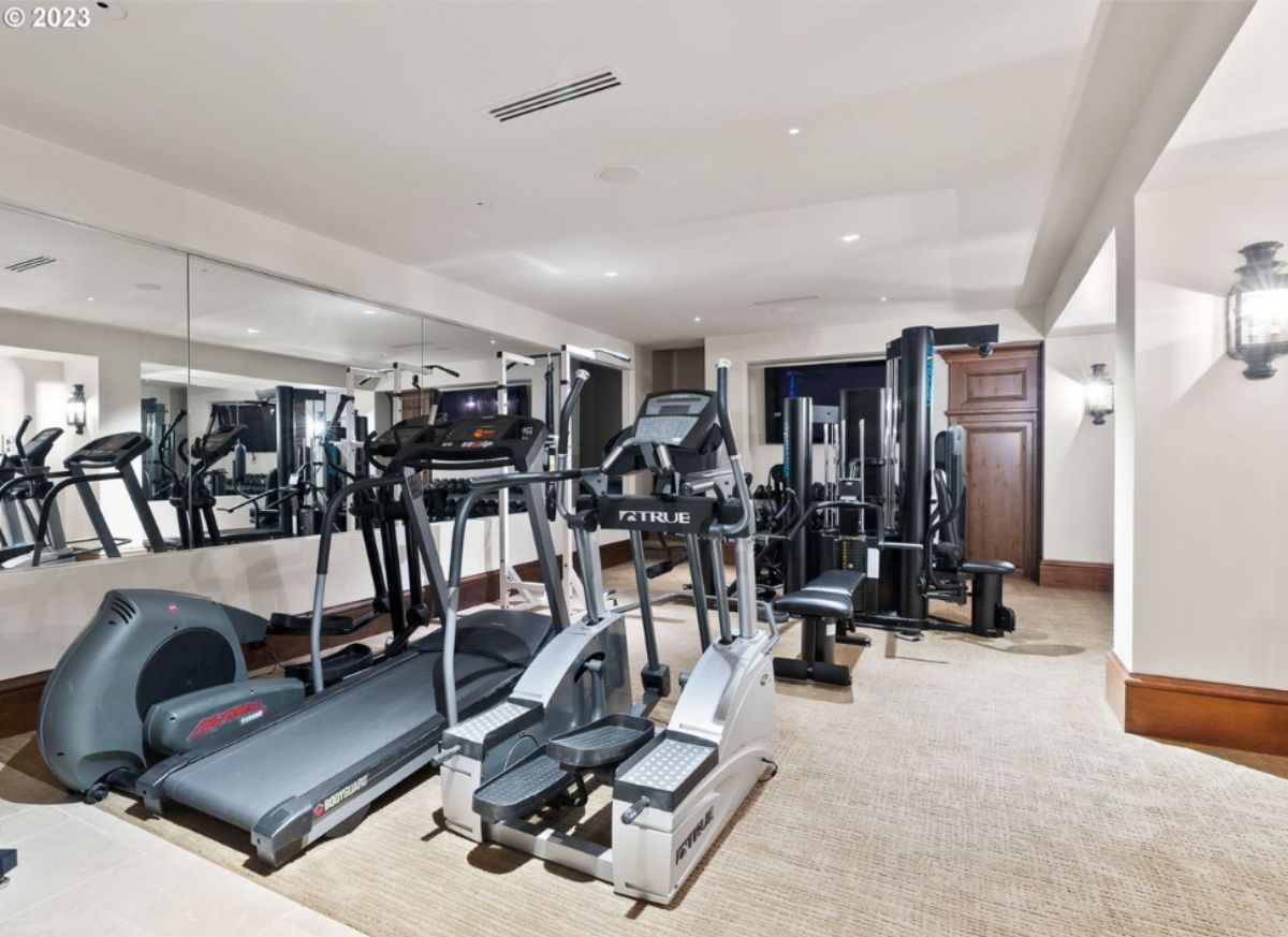 Home gym with workout equipment and custom lights.