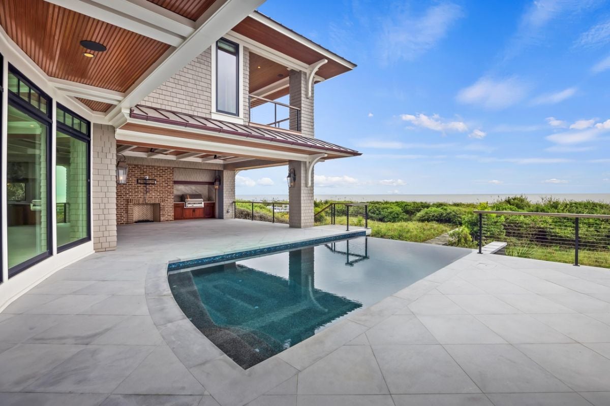 Pool with a grill area and a view of the ocean.