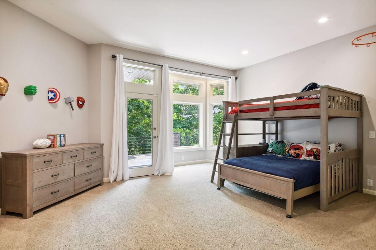 Bedroom with a bunk, carpet flooring, a drawer and a glass door.