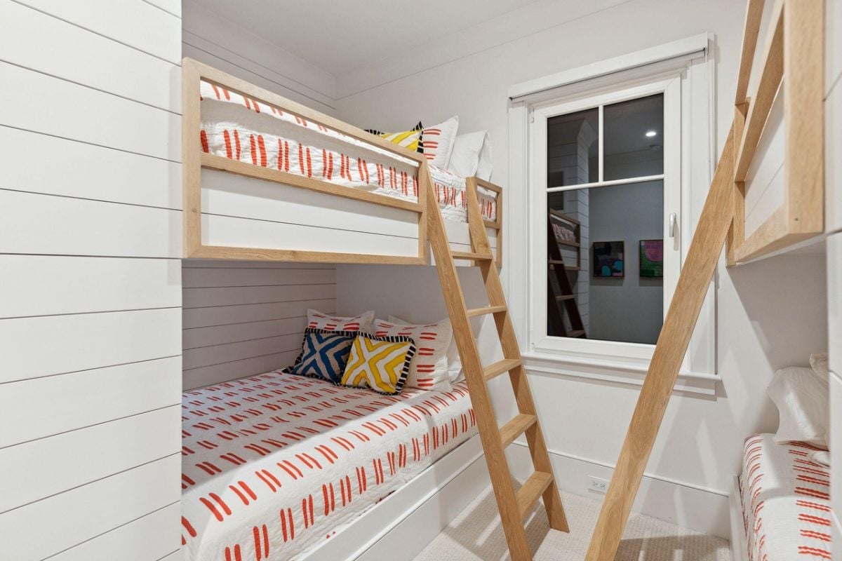 Bedroom with bunks, carpet flooring and glass window.