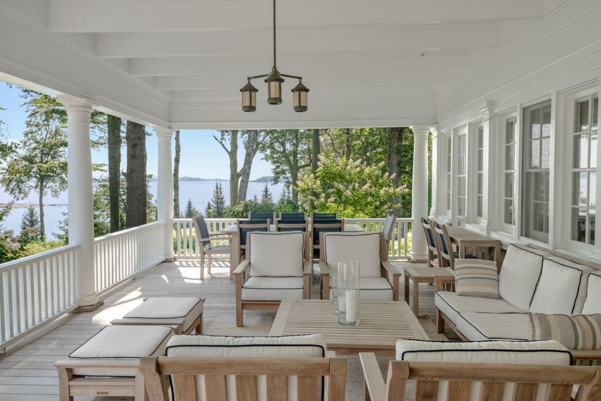 Terrace with couches and wood flooring overlooking the ocean.