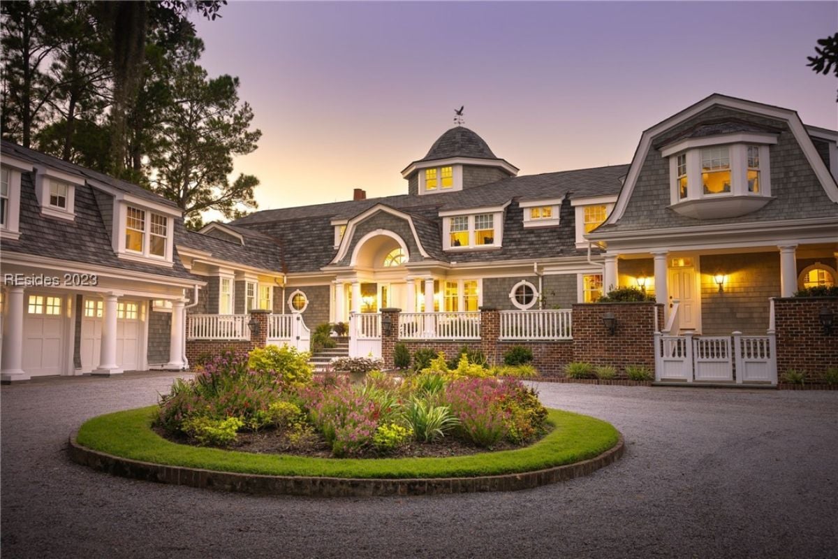 Front view of the mansion with a circular garden in front.