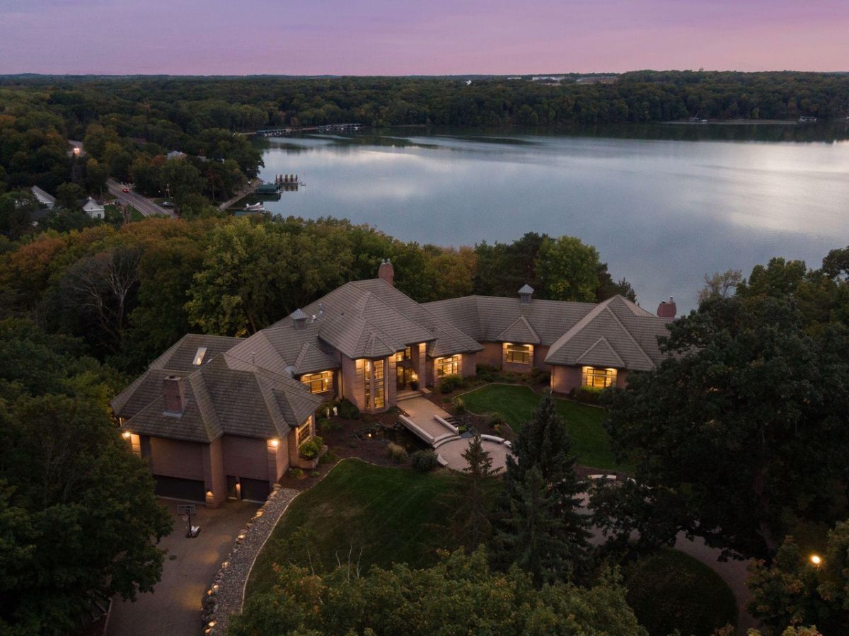 Aerial view of the mansion with a lake in the background.