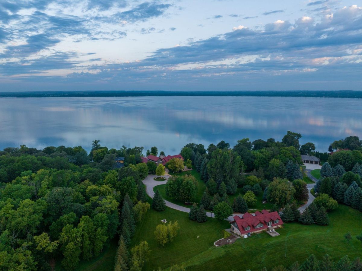 Aerial view of the estate with a lake in the background.