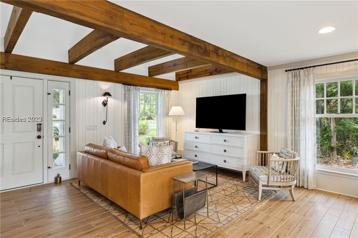 Living room with vaulted ceiling, couch and a TV.