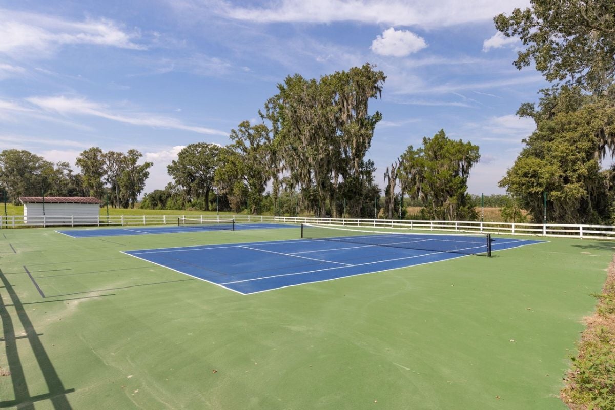 Tennis courts with white fence.