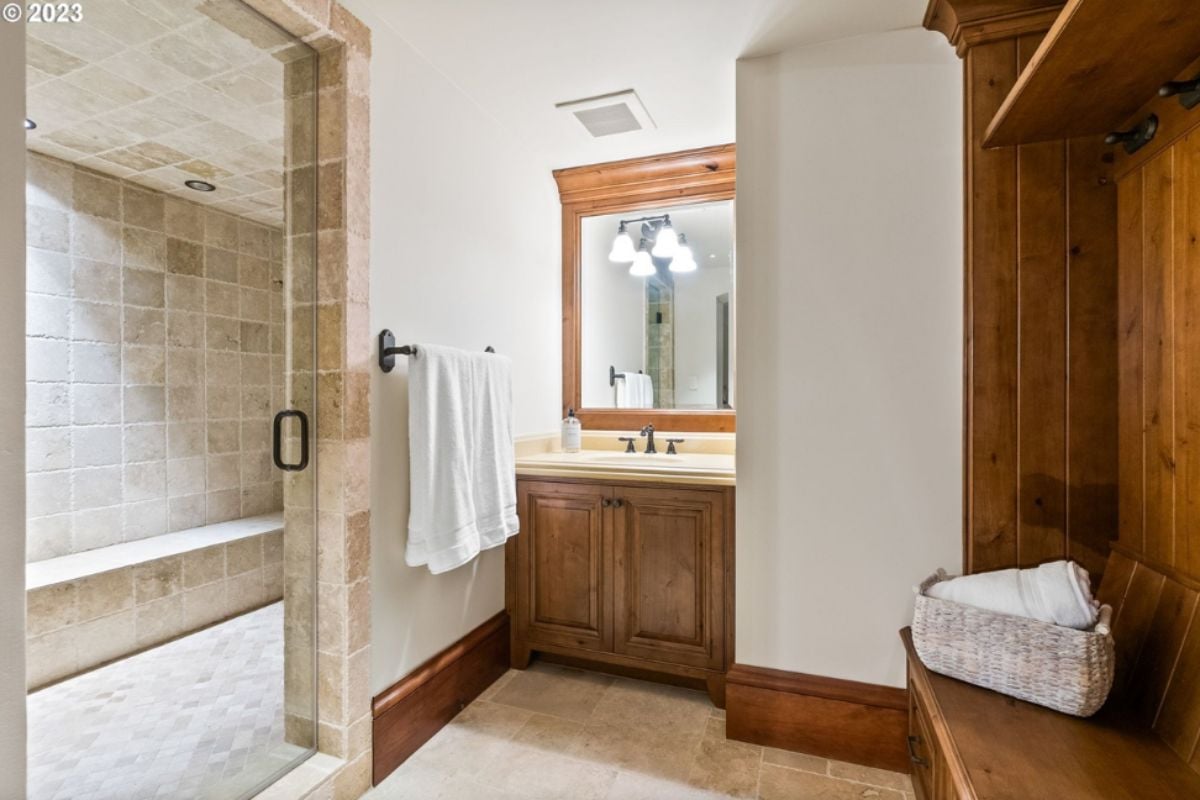 Bathroom with a walk-in shower, sink, and tile flooring.