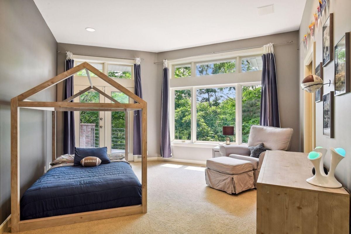 Bedroom with carpet flooring, a couch, glass windows and a glass door.