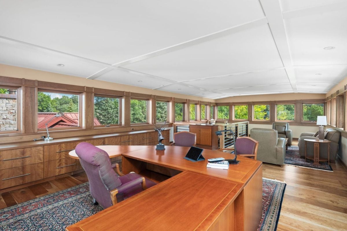 Home office with a large desk, chair and couches.