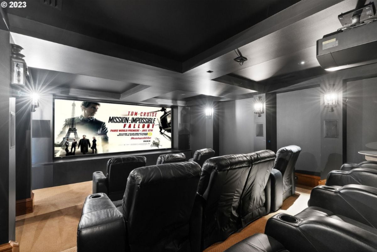 Home theater with large screen, reclining chairs and custom lights.