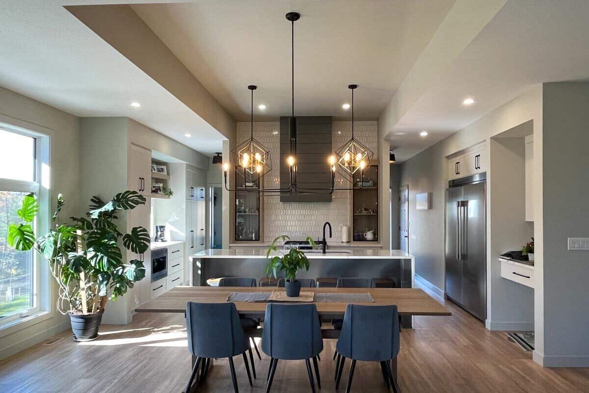 Dining area with a wooden dining set topped with wrought iron pendants.