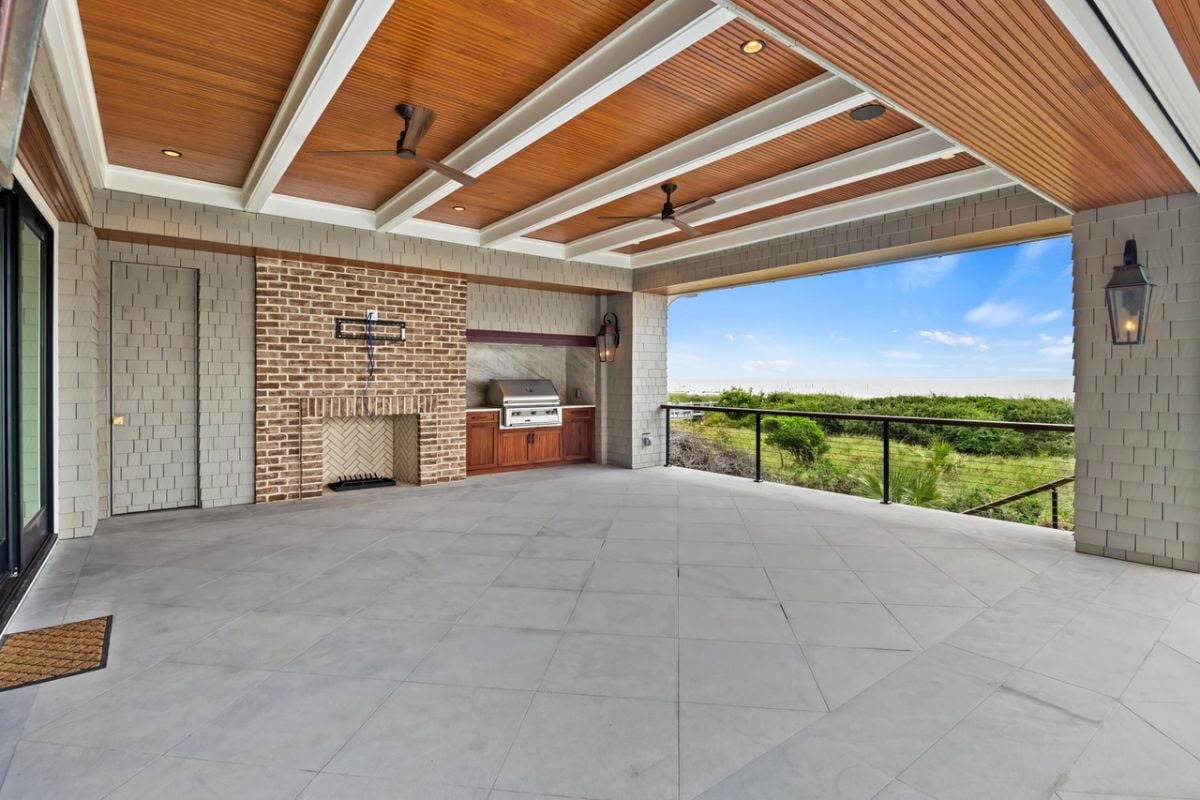 Covered patio with vaulted ceilings, grill area and ceiling fans.