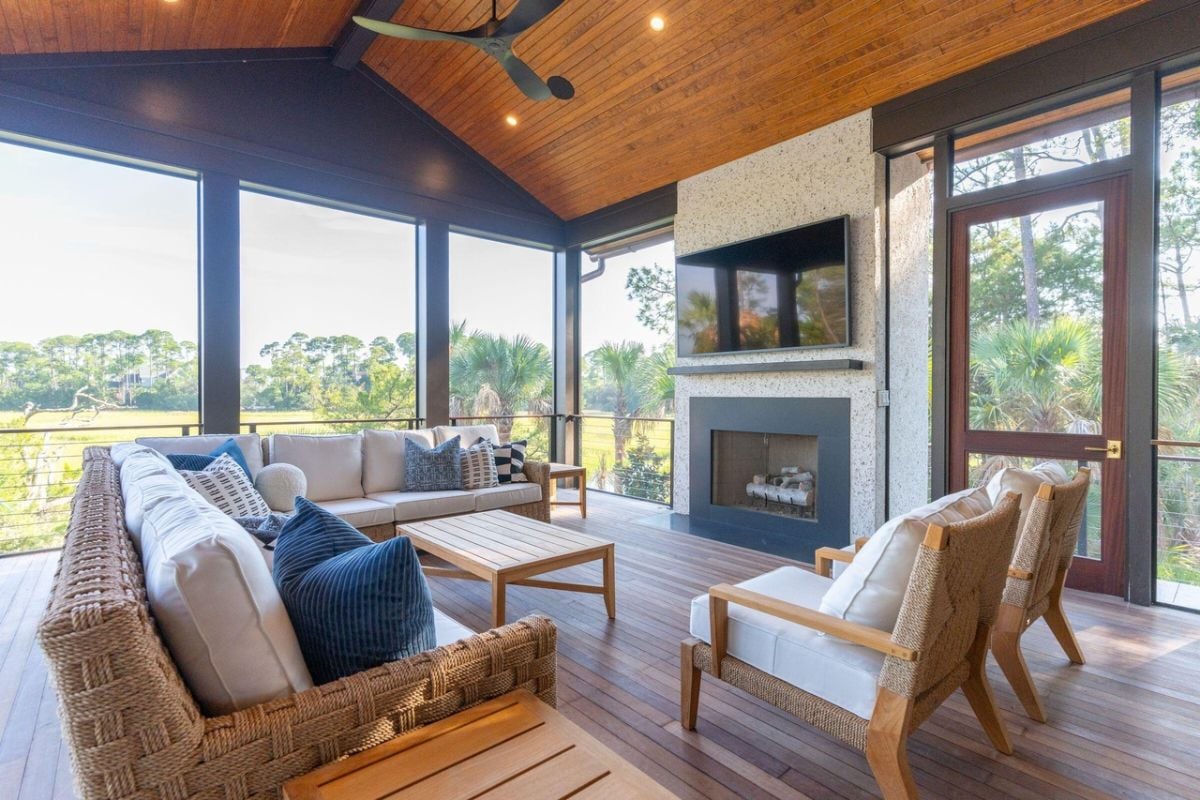 Screened porch with couches, TV and a fireplace.