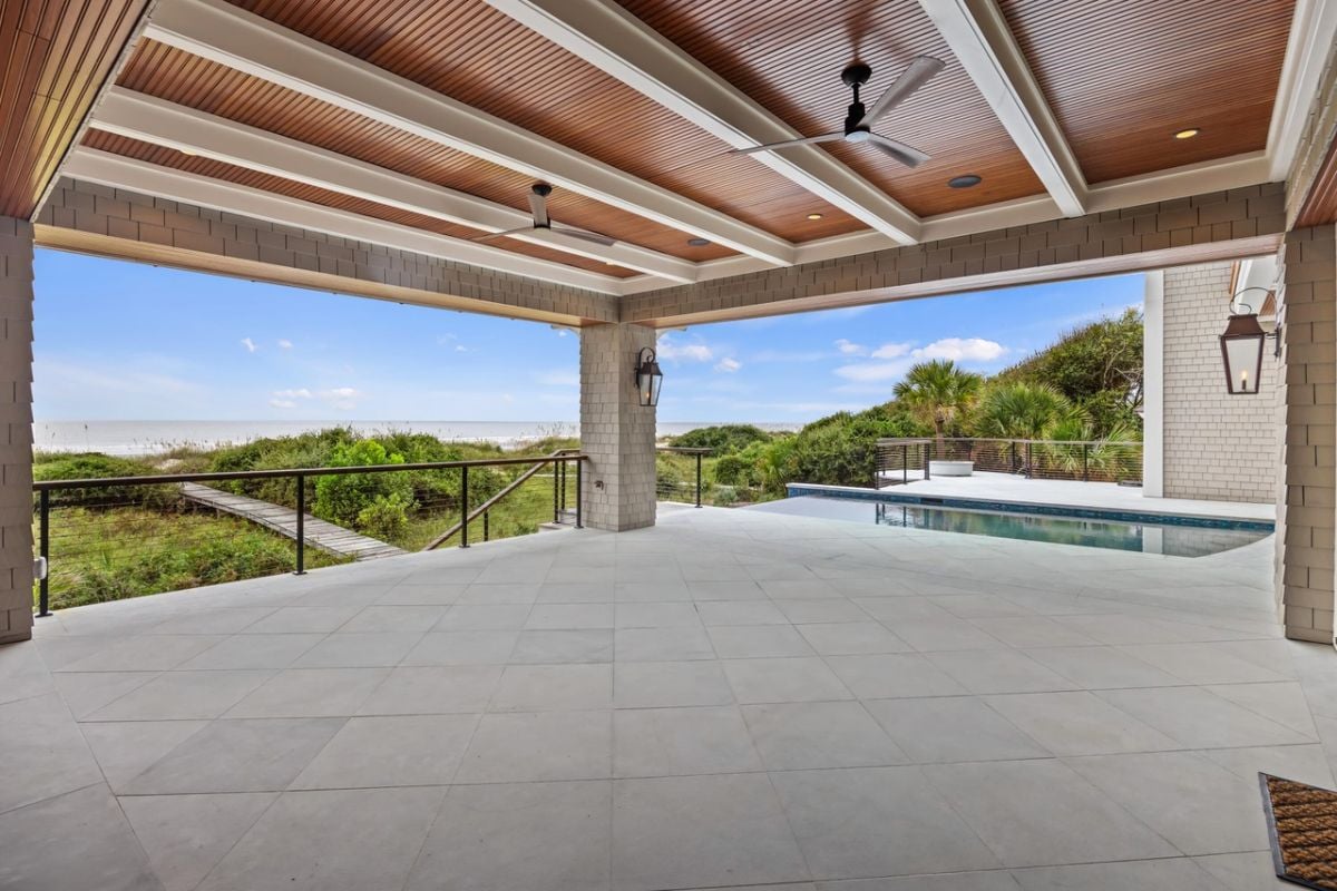 Covered patio with vaulted ceilings, ceiling fans and a view of the ocean.