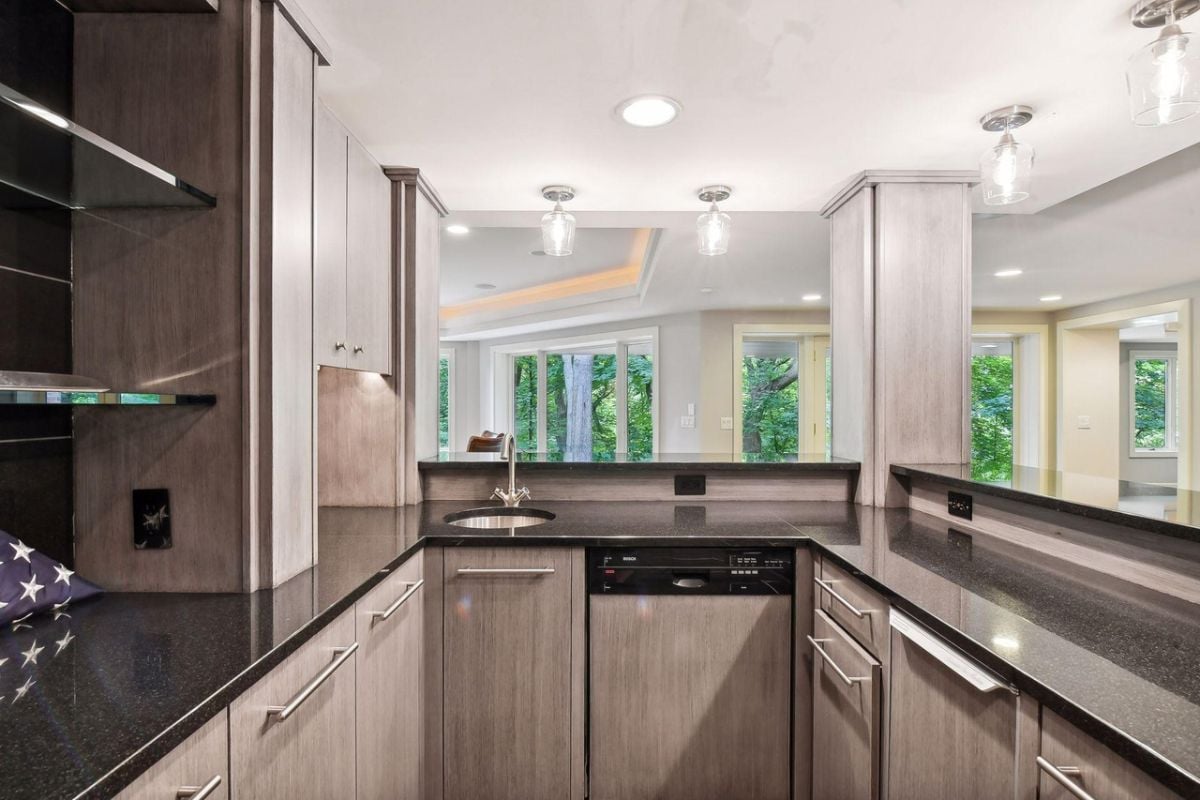 Bar with a sink, custom lights and custom cabinets.