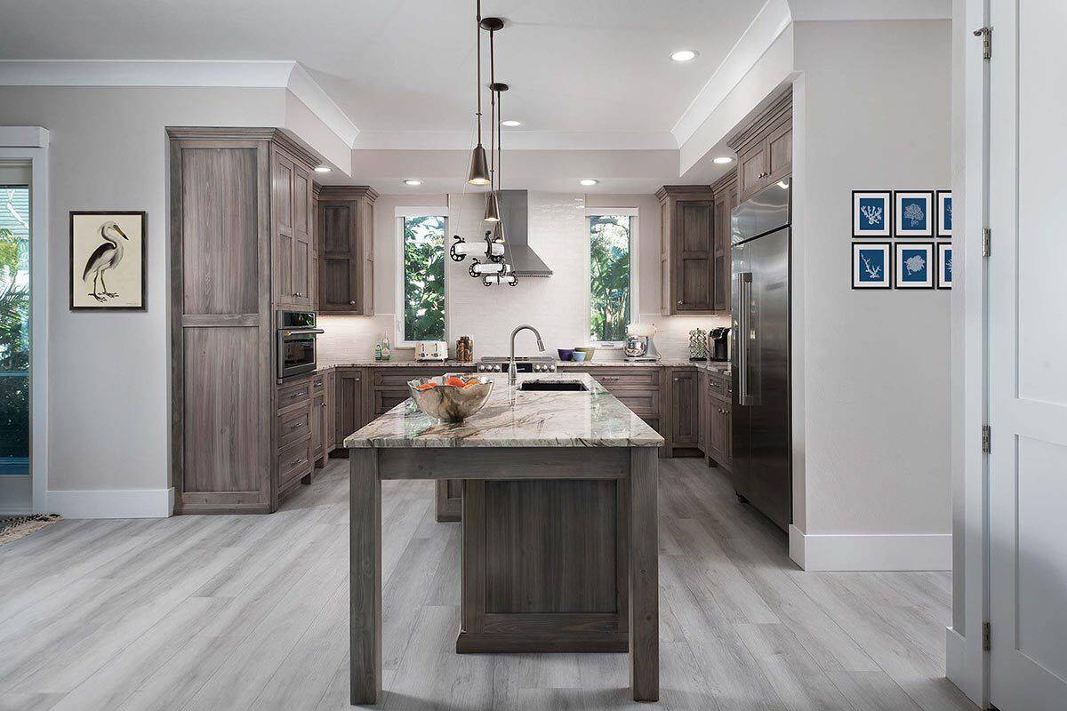 Kitchen with wooden cabinets and a center island fitted with a prep sink.