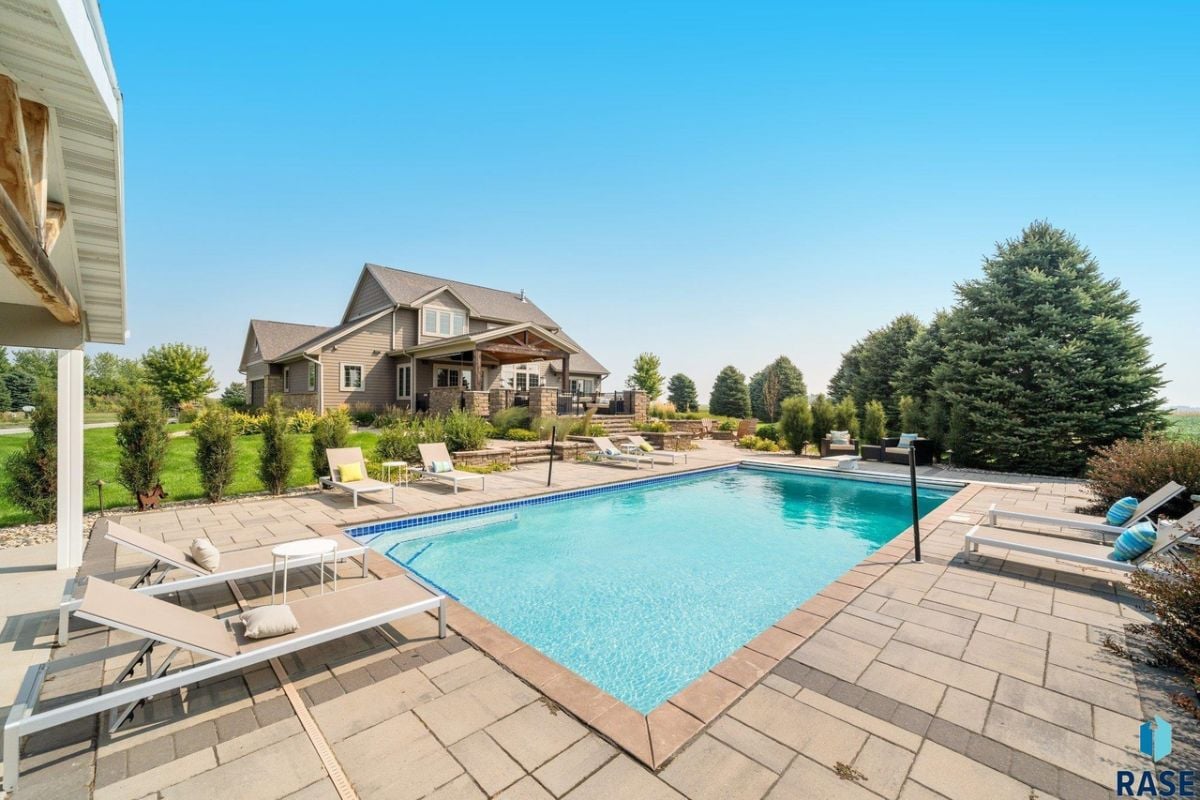Rear view of the house with a pool and lounge chairs.