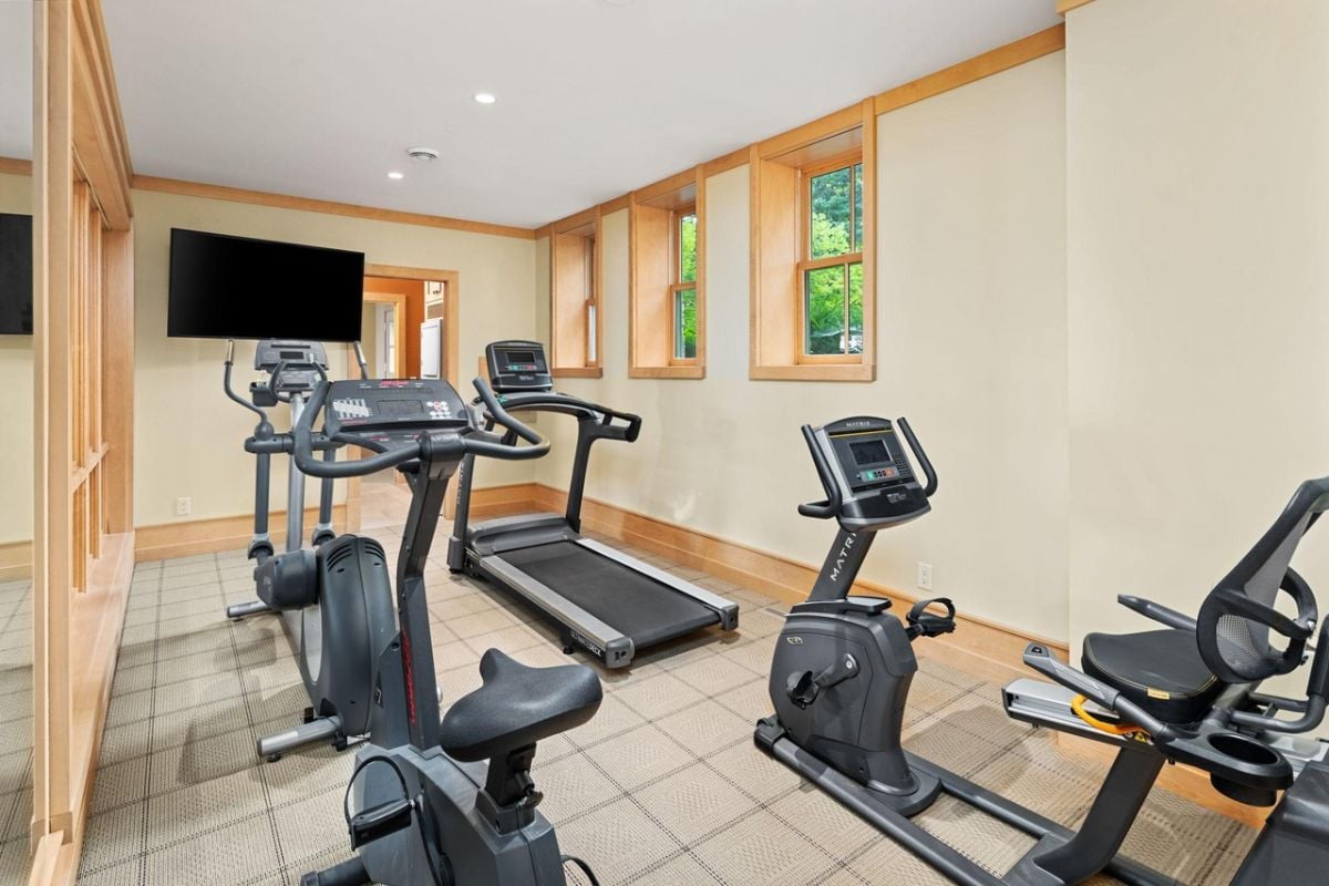 Home gym with a TV and workout equipment.
