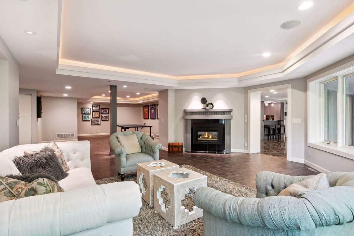 Recreation room with couches, fireplace and a table tennis.