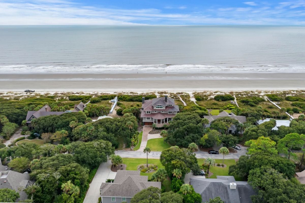 Aerial view of the mansion with the ocean in the background.
