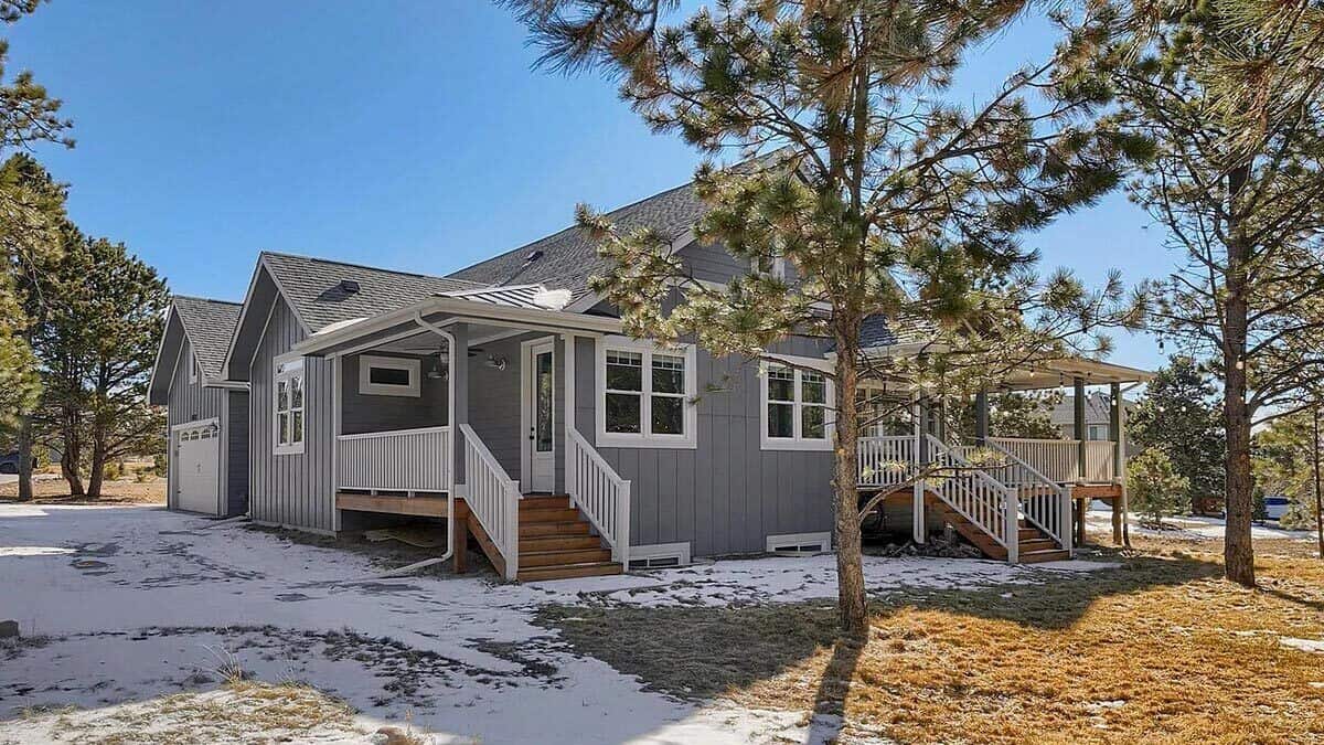 Rear-right view showcasing the covered porches with wooden staircases.