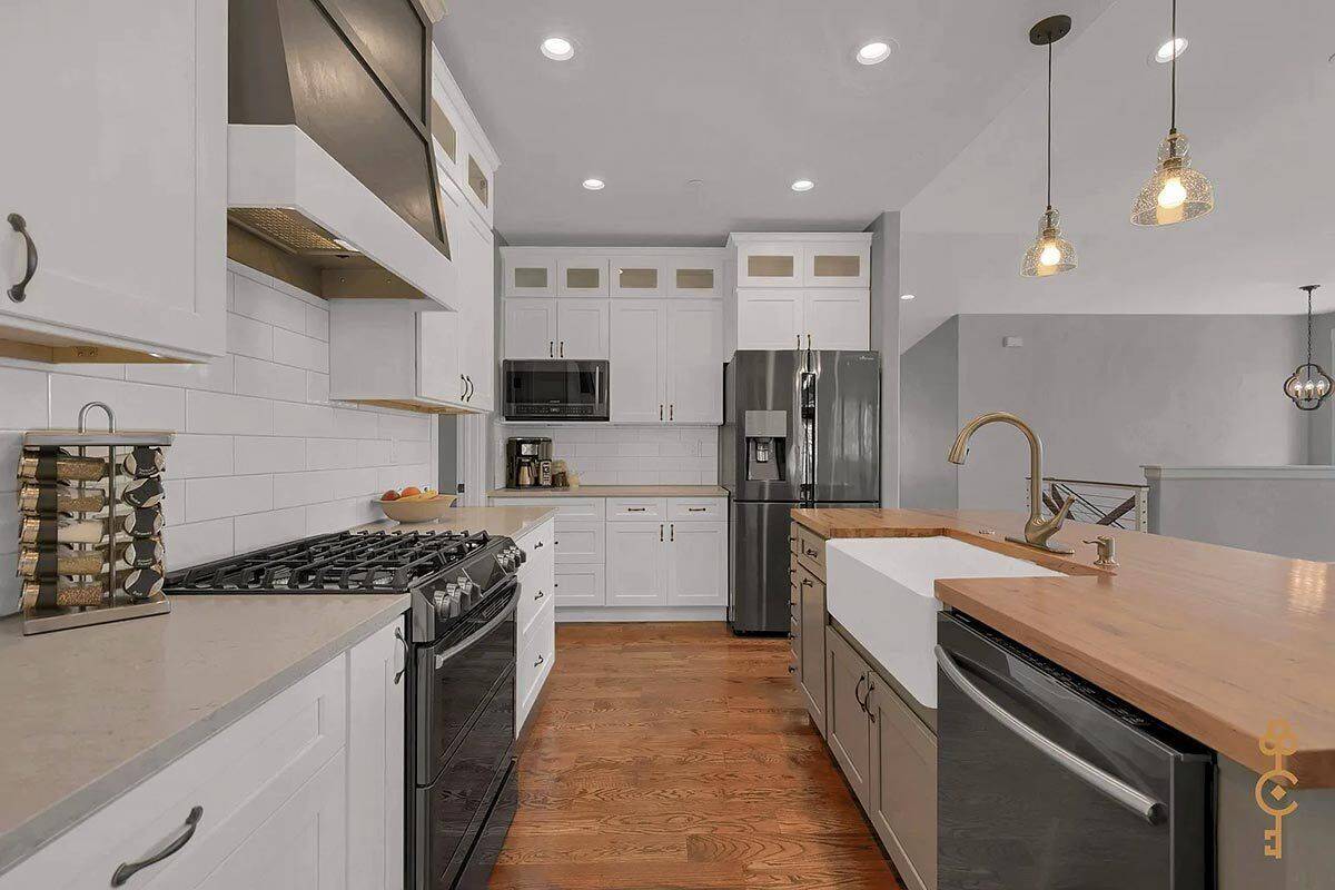 The kitchen includes high-end appliances and a farmhouse sink fitted on the island.
