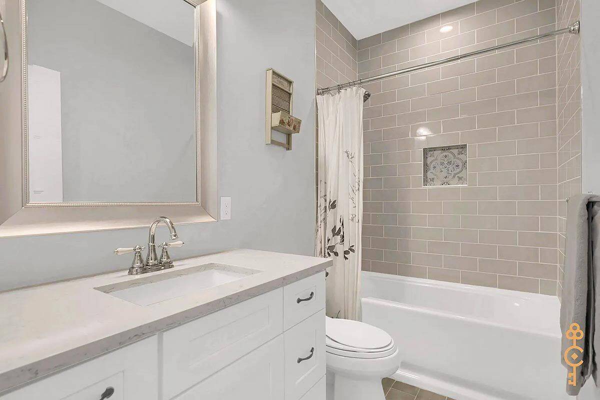 Secondary bathroom with a sink vanity and a tub and shower combo.