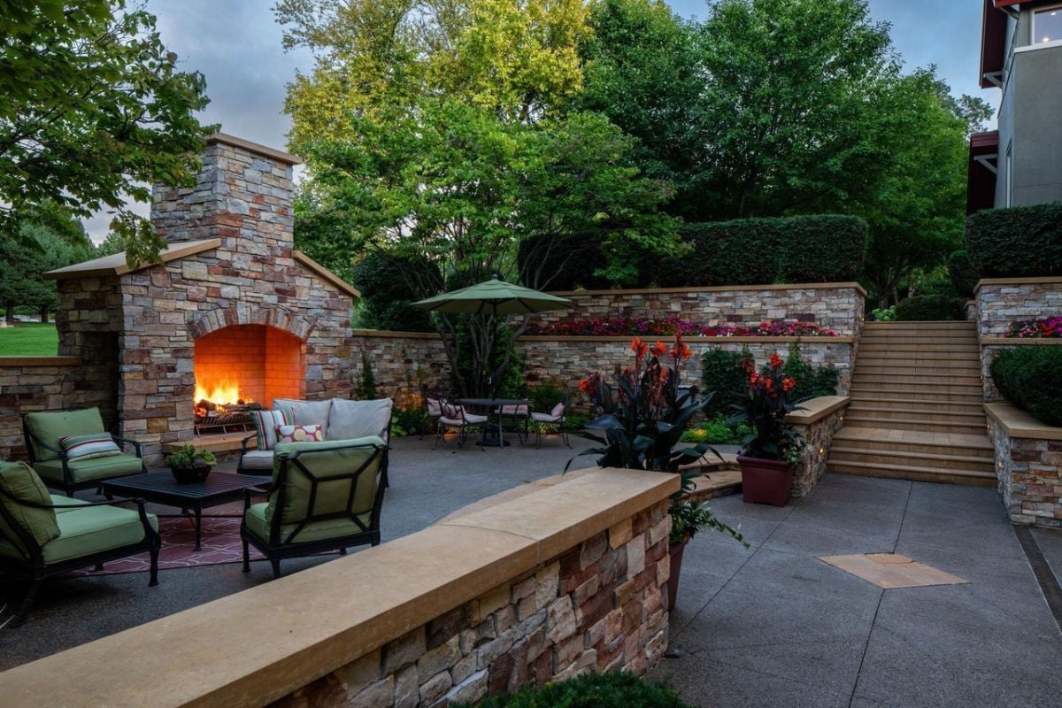 Patio with a table, chairs and a fireplace.
