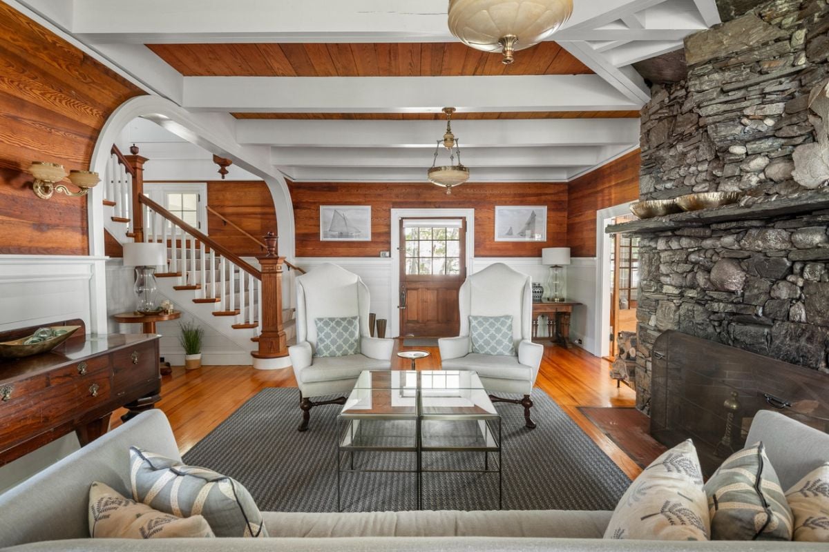 Living room with couches, rug, chandelier, wood flooring and vaulted ceiling.