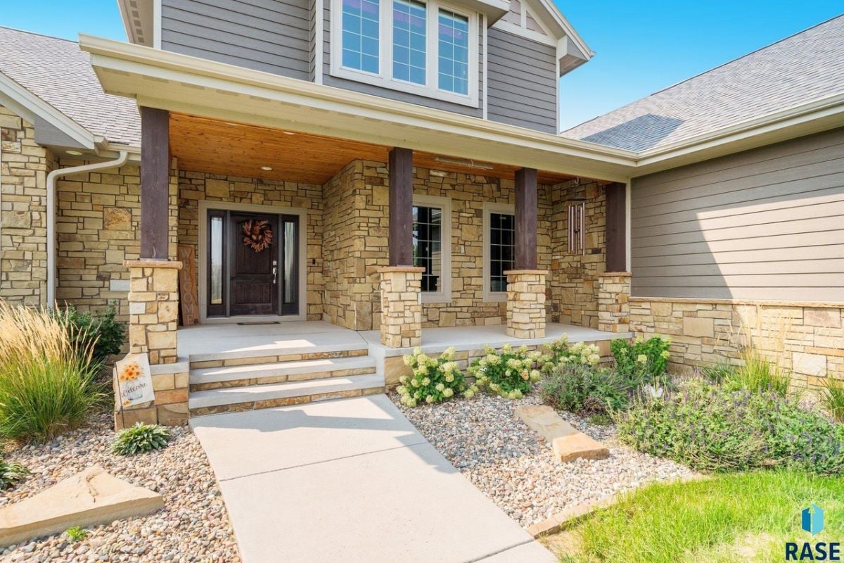 Front entry of the property with a wooden door and a porch.