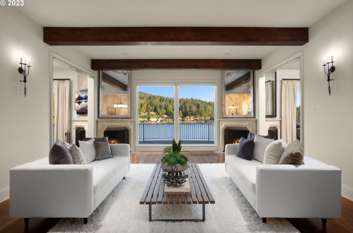 Living room with couches, glass doors, fireplace and a large rug.