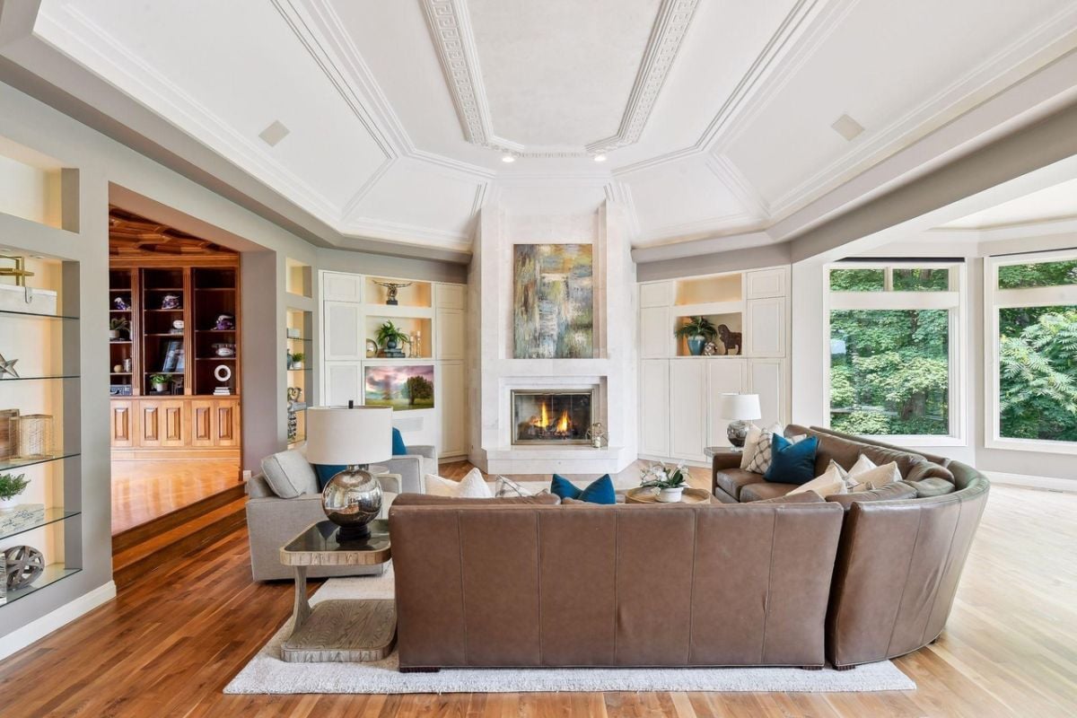 Living room with couches, wooden floors and a fireplace.