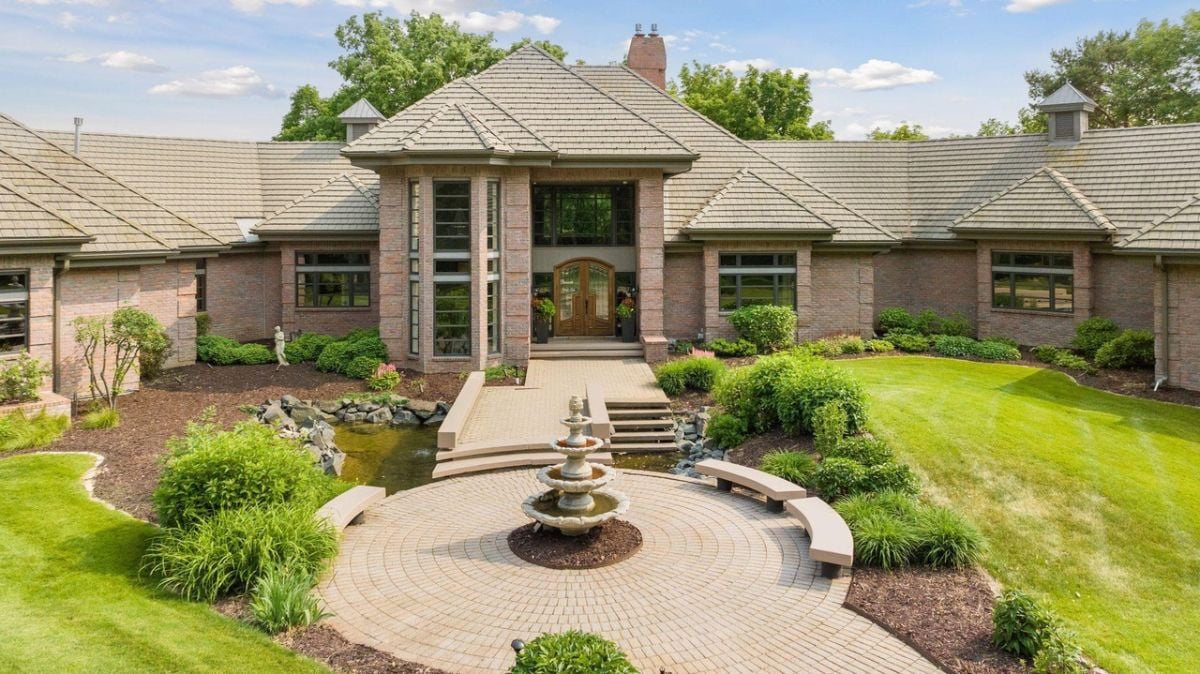 Front view of the house with landscaped yard and a fountain.