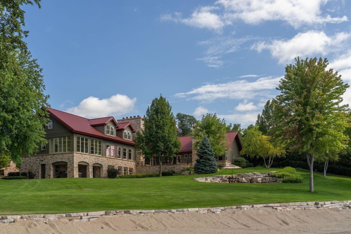 Backyard of the house with a large green lawn.