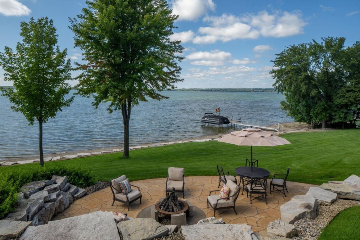 Fire pit with a table, chairs and a view of the lake.